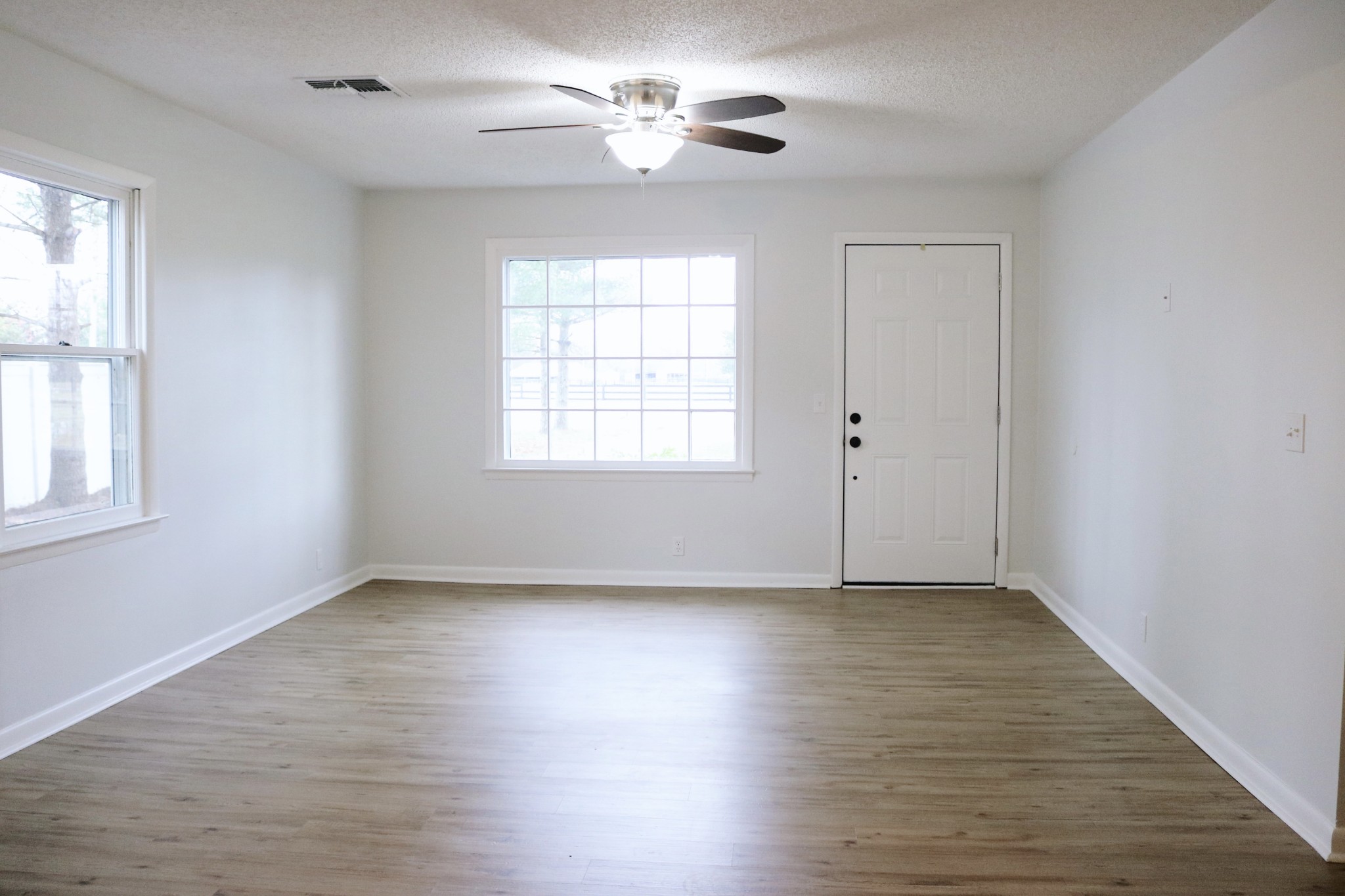 3322 Fann Road Murfreesboro, TN 37128 - Photo 16 of 29 an empty room with wooden floor chandelier fan and windows