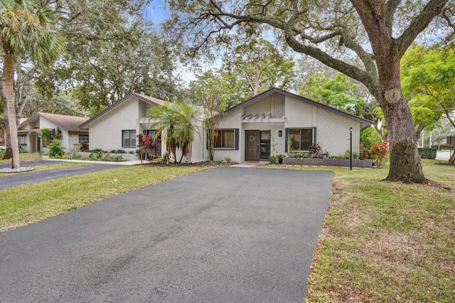 a front view of a house with a yard and trees