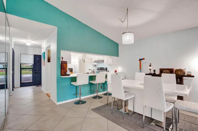 a large white kitchen with a sink and refrigerator