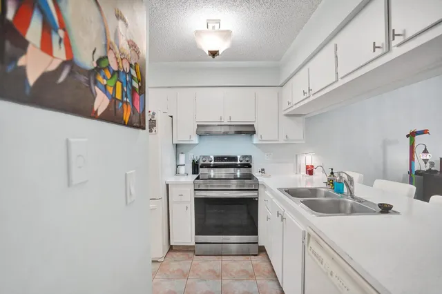 a kitchen with white cabinets and appliances