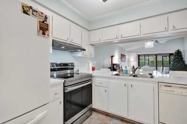 a kitchen with stainless steel appliances a stove a refrigerator and a fireplace