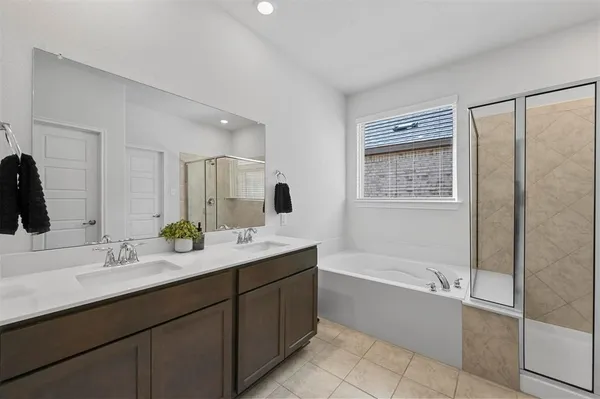a bathroom with a tub sink and mirror