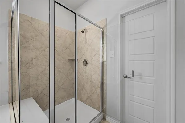 a bathroom with a glass shower door
