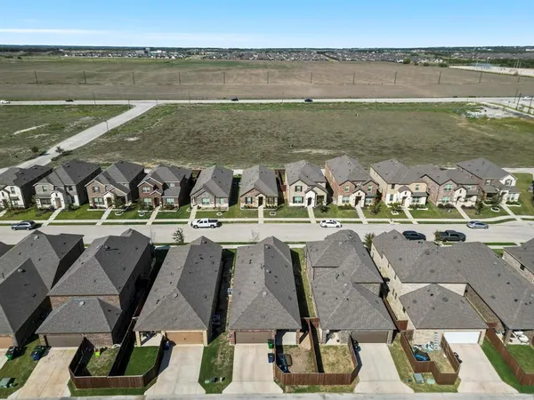 an aerial view of residential houses with outdoor space and lake view