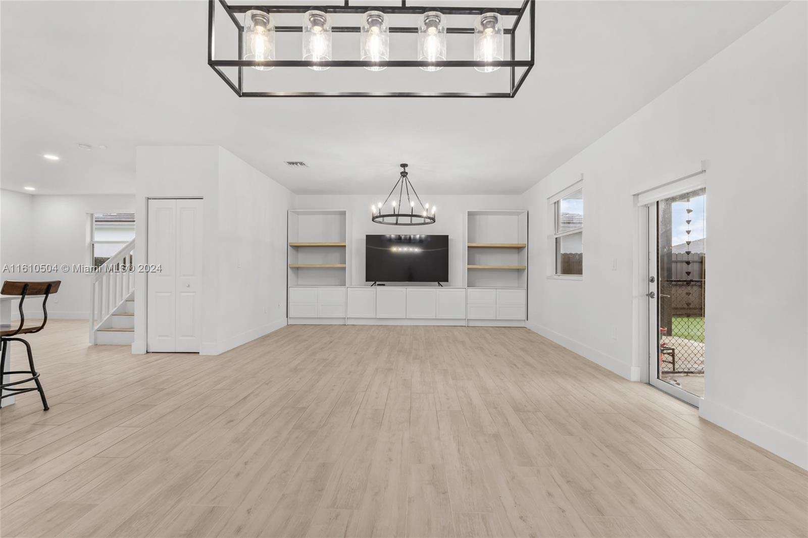 12743 Southwest 211th Street Miami, FL 33177 - Photo 17 of 38 a view of a livingroom with wooden floor and a ceiling fan