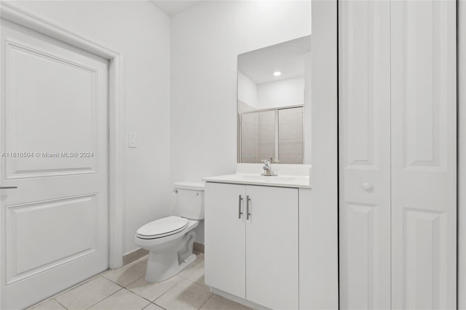 12743 Southwest 211th Street Miami, FL 33177 - Photo 19 of 38 a bathroom with a toilet a sink and mirror