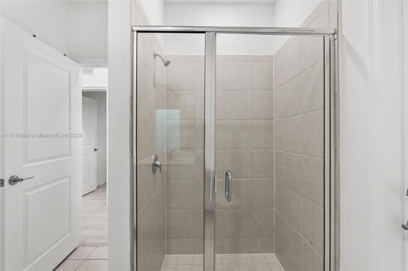 12743 Southwest 211th Street Miami, FL 33177 - Photo 20 of 38 a bathroom with a glass shower door