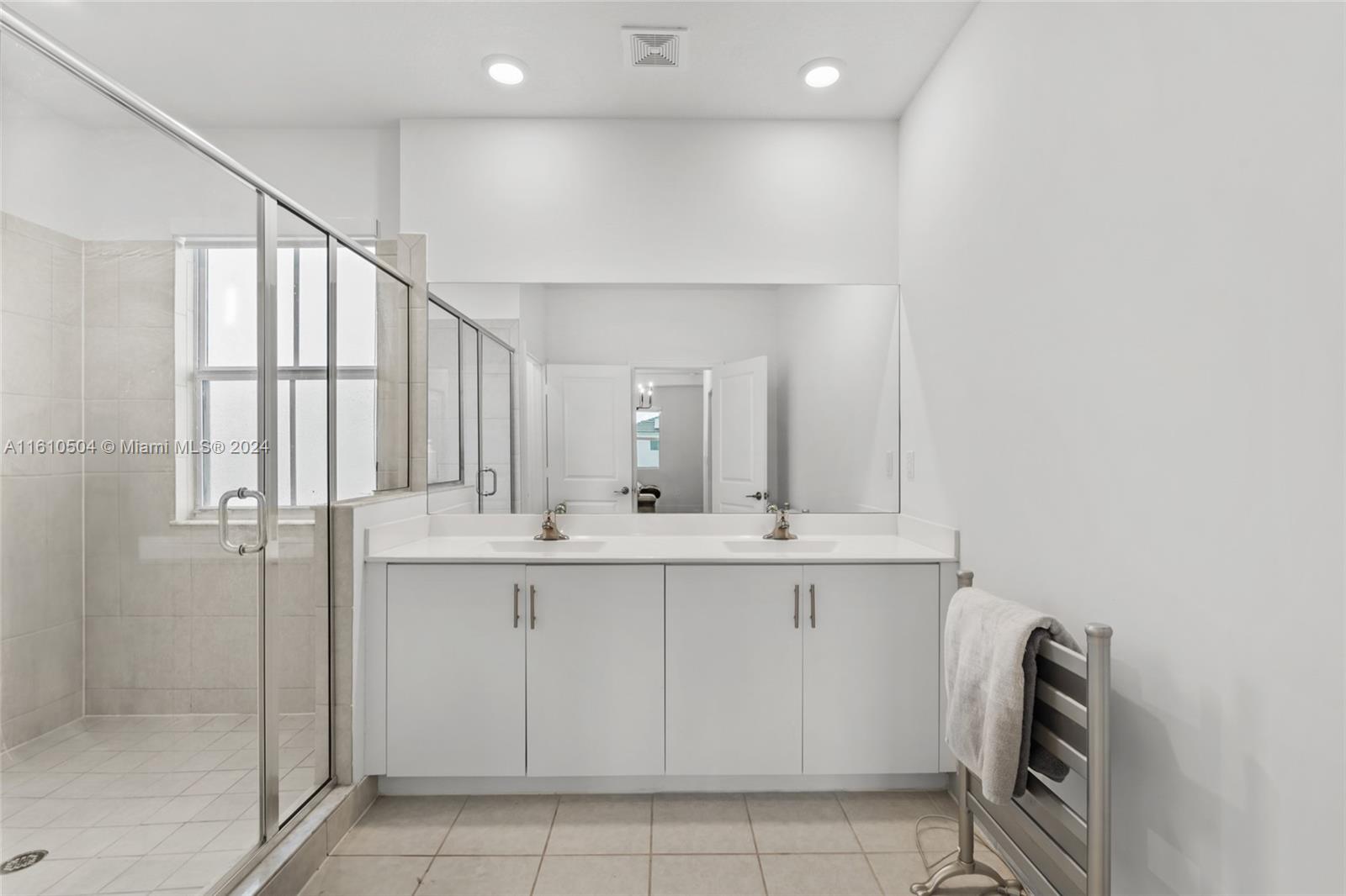 12743 Southwest 211th Street Miami, FL 33177 - Photo 30 of 38 a bathroom with a sink a mirror and a shower