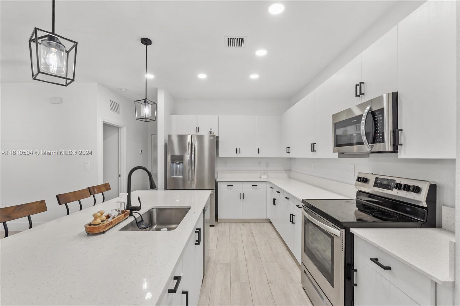 12743 Southwest 211th Street Miami, FL 33177 - Photo 8 of 38 a kitchen with a sink a stove and cabinets
