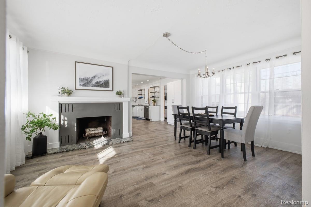 16256 West 13 Mile Road Southfield, MI 48076 - Photo 12 of 30 Dining space with light wood-style flooring, a fireplace, and a chandelier