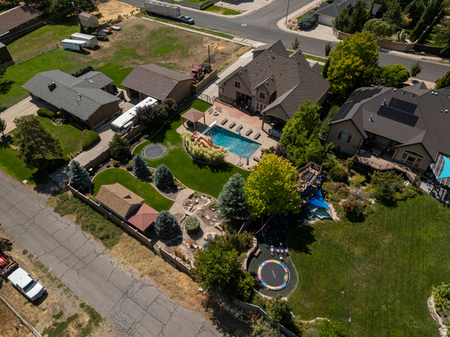 687 South 2080th Street East Springville, UT 84663 - Photo 71 of 149 Expansive backyard featuring a large in-ground swimming pool with surrounding hardscaping, a covered patio area, mature trees, and a manicured lawn