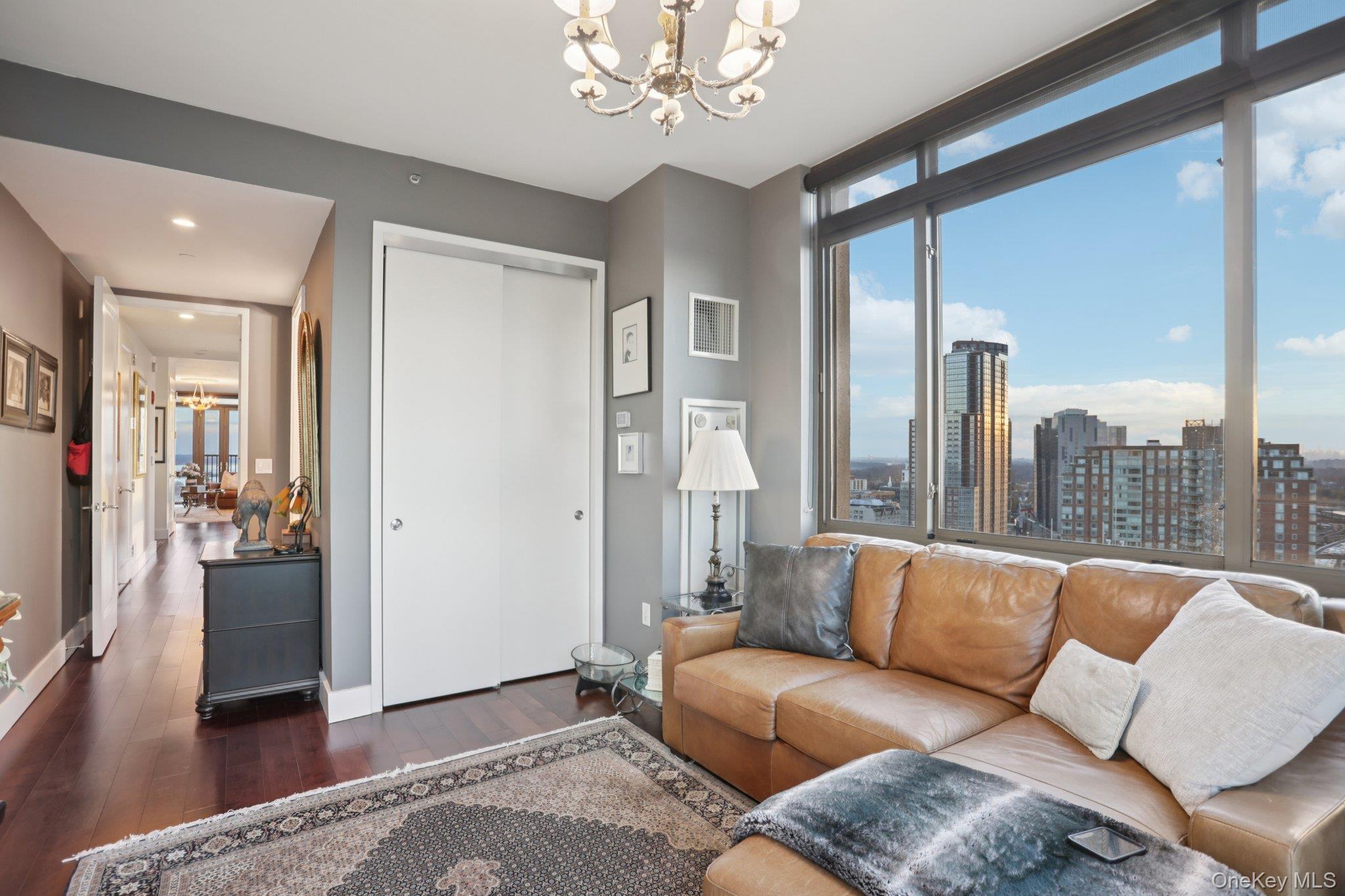 175 Huguenot Street, Unit 2403 New Rochelle, NY 10801 - Photo 11 of 30 a living room with furniture and a chandelier