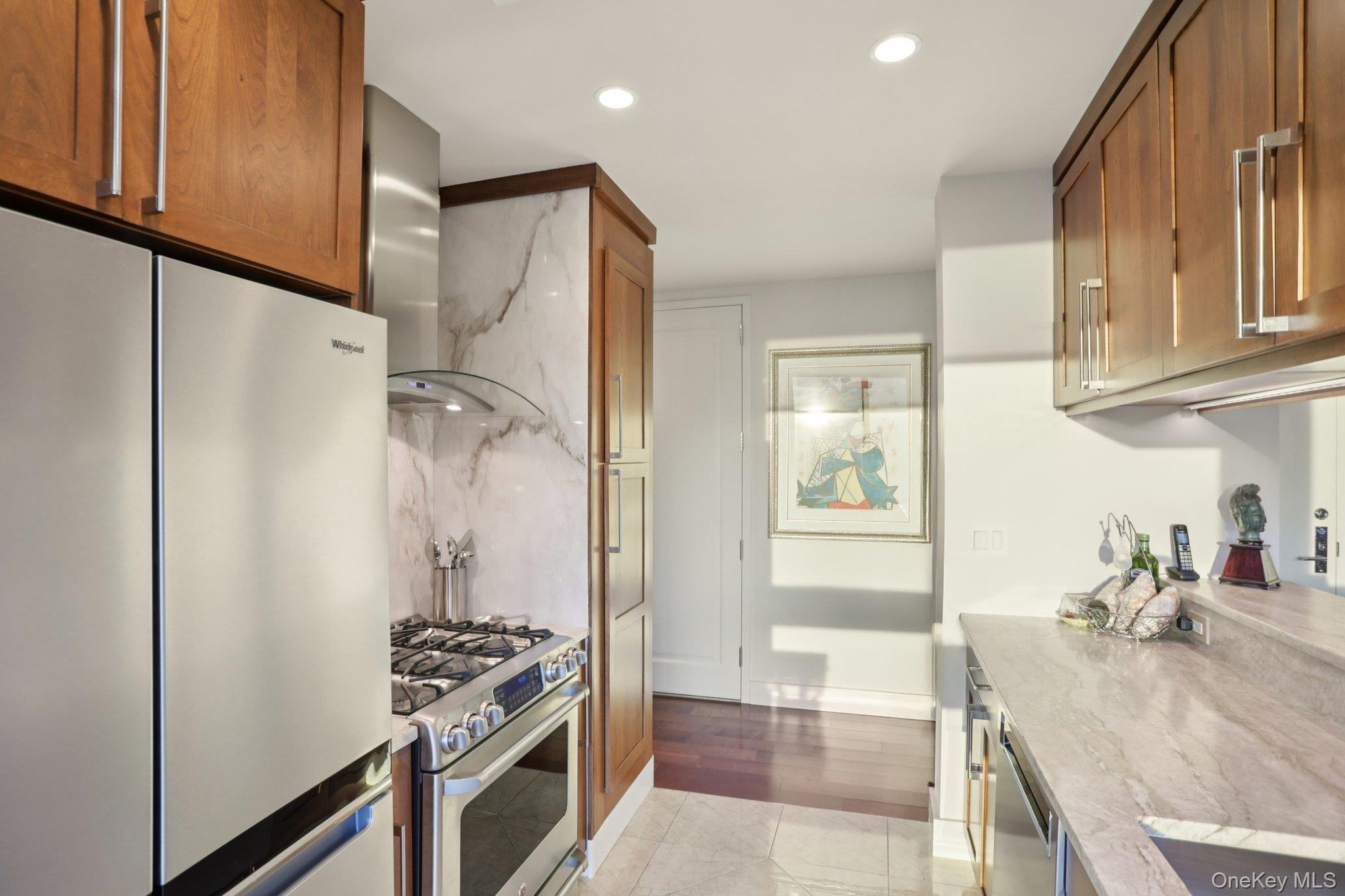 175 Huguenot Street, Unit 2403 New Rochelle, NY 10801 - Photo 17 of 30 a kitchen with stainless steel appliances granite countertop a refrigerator and a stove