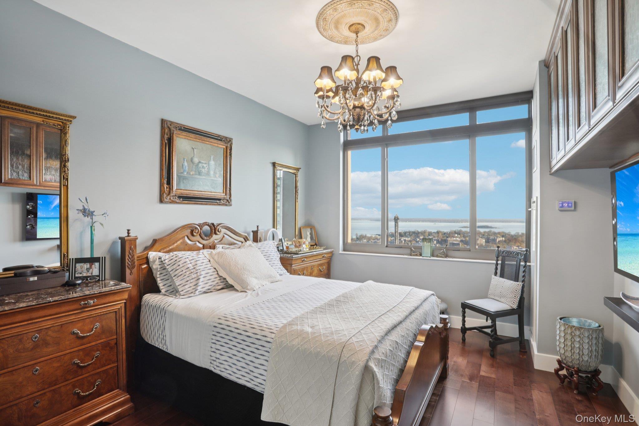 175 Huguenot Street, Unit 2403 New Rochelle, NY 10801 - Photo 18 of 30 a bedroom with a large bed and a chandelier