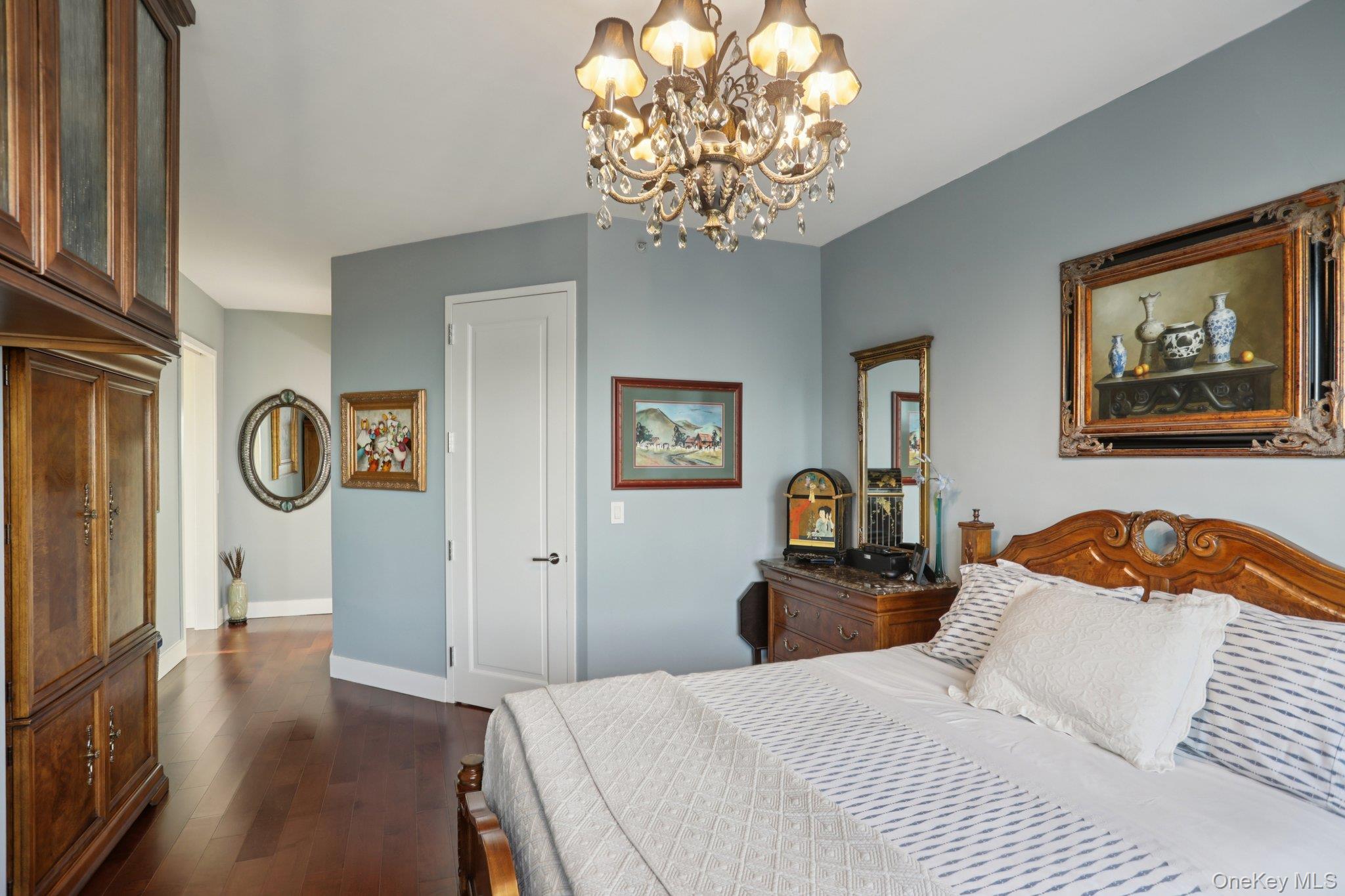 175 Huguenot Street, Unit 2403 New Rochelle, NY 10801 - Photo 19 of 30 a bedroom with a bed and a chandelier