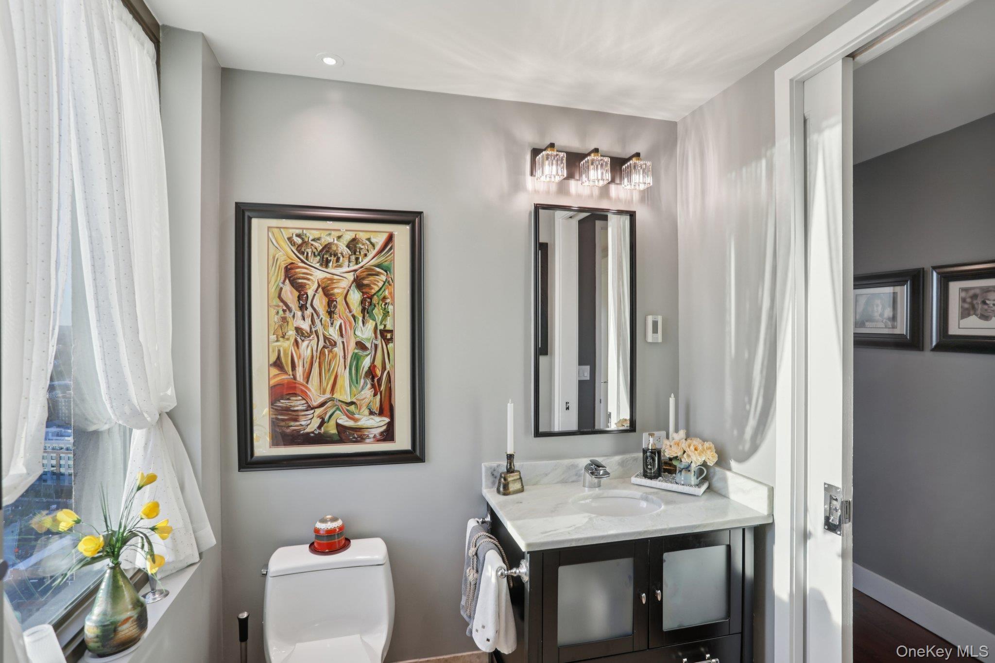175 Huguenot Street, Unit 2403 New Rochelle, NY 10801 - Photo 23 of 30 a bathroom with a sink mirror and vanity
