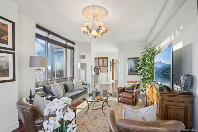 a living room with furniture and a chandelier