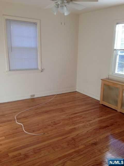 2-8 New Street, Unit 8A Tenafly, NJ 07670 - Photo 18 of 29 an empty room with wooden floor and windows