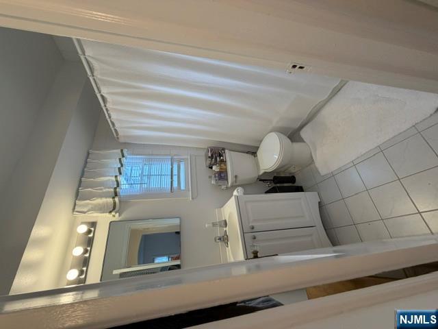 2-8 New Street, Unit 8A Tenafly, NJ 07670 - Photo 23 of 29 a bathroom with a sink a toilet and mirror