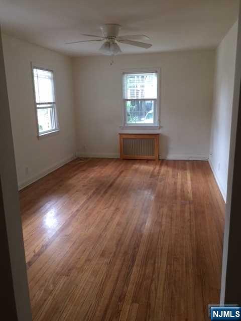 2-8 New Street, Unit 8A Tenafly, NJ 07670 - Photo 7 of 29 a view of an empty room with wooden floor and a window