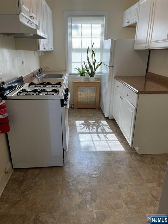 2-8 New Street, Unit 8A Tenafly, NJ 07670 - Photo 8 of 29 a kitchen with stainless steel appliances a stove a refrigerator a sink a stove and white cabinets