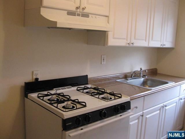 2-8 New Street, Unit 8A Tenafly, NJ 07670 - Photo 9 of 29 a white stove top oven sitting inside of a kitchen