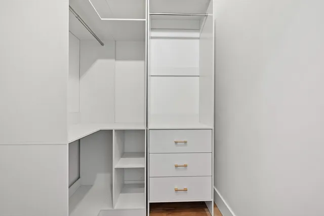 a view of walk in closet with empty racks