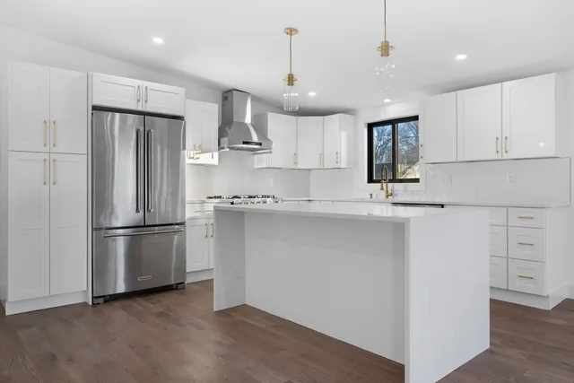a kitchen with kitchen island white cabinets and stainless steel appliances