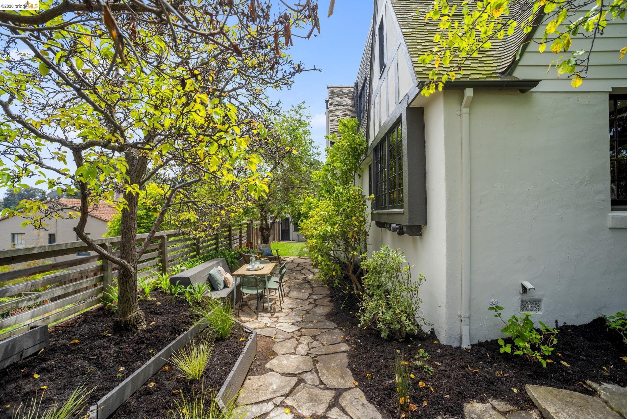 1087 Hubert Road Oakland, CA 94610 - Photo 62 of 67 Side yard featuring a natural stone pathway, mature trees, and a wooden fence