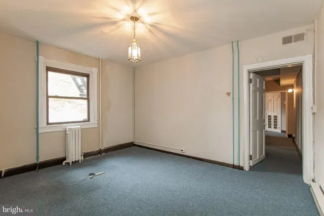 a view of empty room with fireplace and fan
