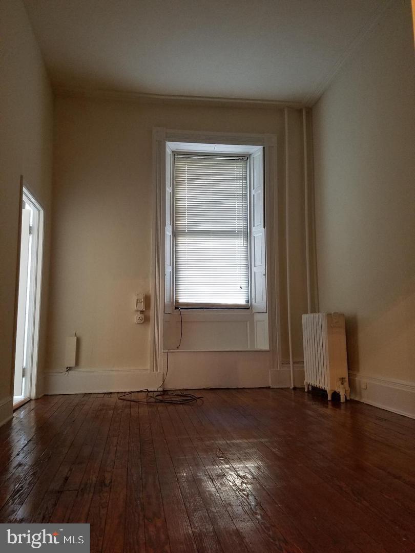 18 West Franklin Street Baltimore, MD 21201 - Photo 27 of 58 an empty room with wooden floor cabinet and windows