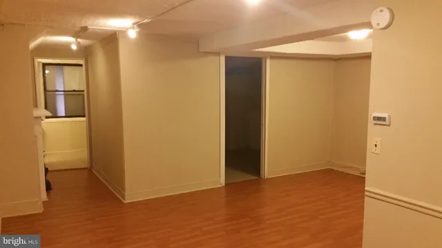 a view of empty room with fireplace and wooden floor