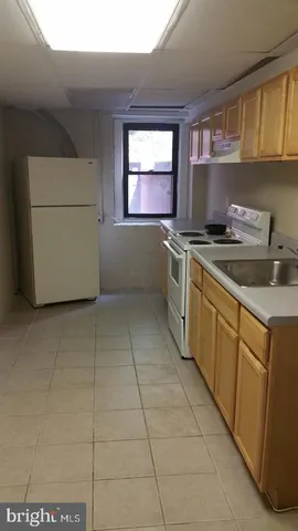 a view of a kitchen with a sink and a refrigerator