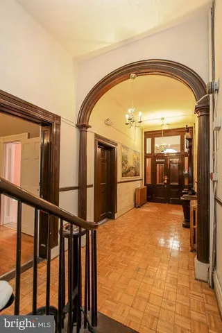 a view of a livingroom with a fireplace a chandelier a ceiling fan and wooden floor