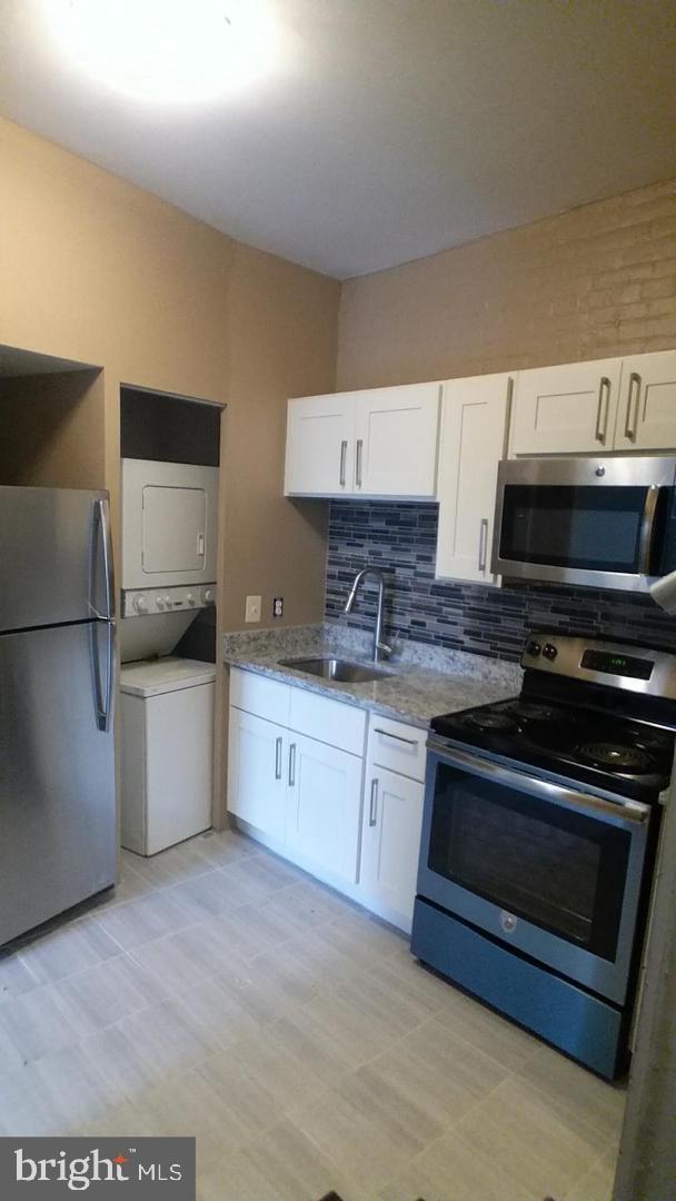 18 West Franklin Street Baltimore, MD 21201 - Photo 52 of 58 a kitchen with stainless steel appliances granite countertop a stove a sink and a microwave