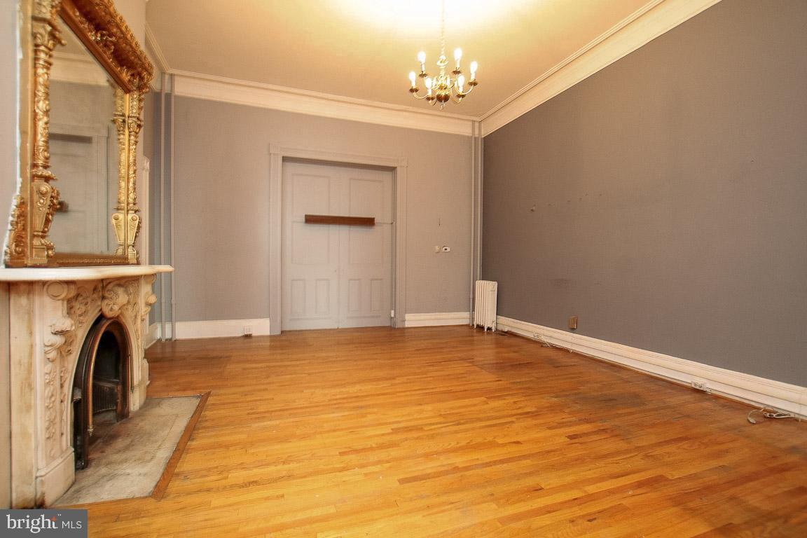 18 West Franklin Street Baltimore, MD 21201 - Photo 8 of 58 a view of a livingroom with a fireplace a chandelier and wooden floor