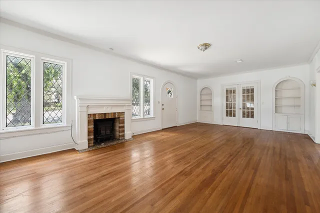 a view of empty room with wooden floor and fireplace