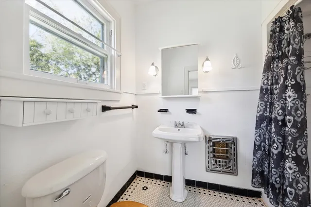 a bathroom with a toilet a sink and a window