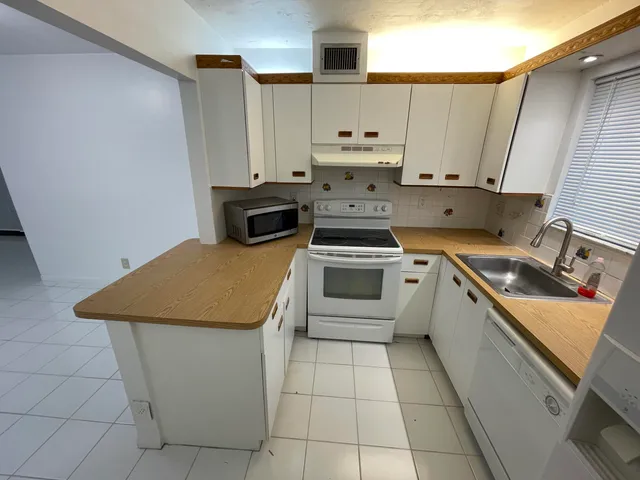 a kitchen with a stove sink and cabinets