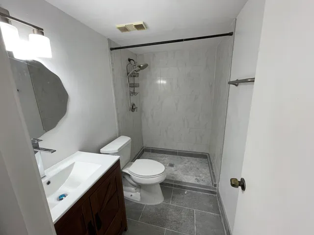 a white toilet sitting next to a bathroom sink