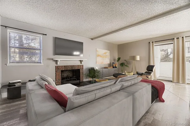 a living room with furniture large window and a fireplace
