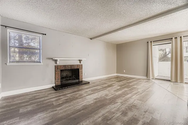 a view of an empty room with window and fire place