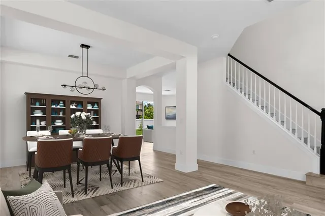a dining room with furniture a chandelier and wooden floor