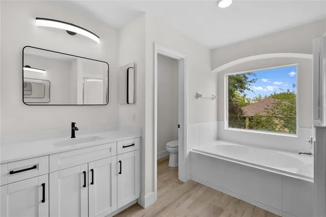 a bathroom with a double vanity sink a mirror and a bathtub