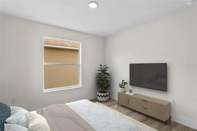 a bedroom with a bed and flat screen tv