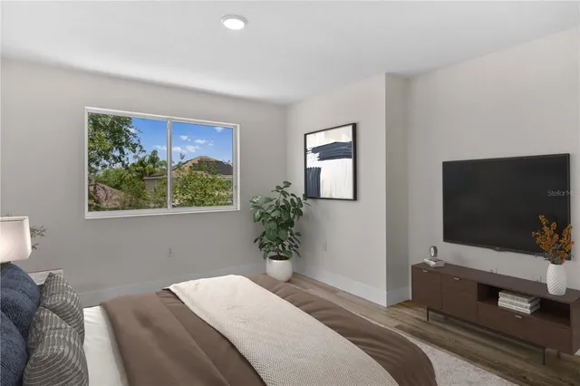 a bedroom with a bed and a flat screen tv