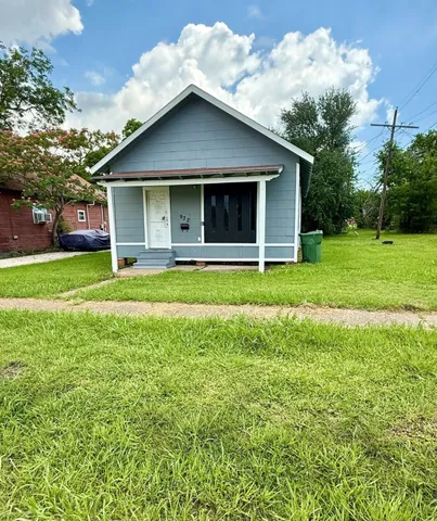 a white house that has a big yard with wooden fence