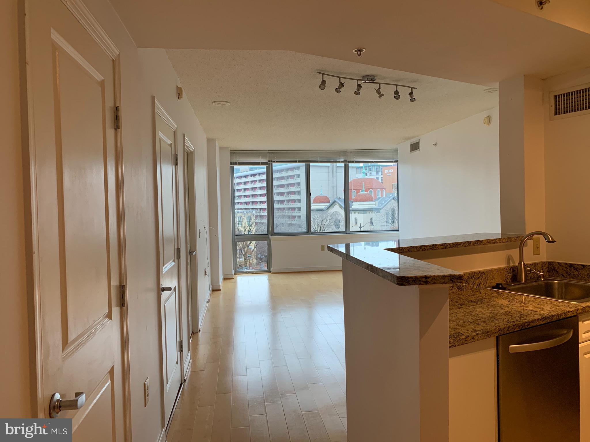 555 Massachusetts Avenue Northwest, Unit 503 Washington, DC 20001 - Photo 4 of 24 a kitchen with stainless steel appliances granite countertop a sink and a refrigerator