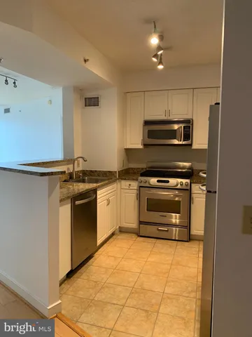 a kitchen with granite countertop a stove and a refrigerator
