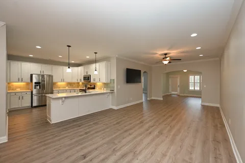 a view of large kitchen with cabinets and wooden floor